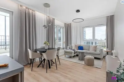 a dining room and living room with a table and chairs at Blue Blue Apartment in Kraków