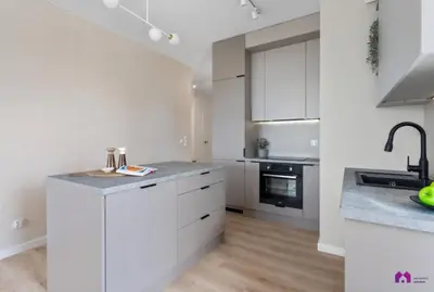 a white kitchen with white cabinets and a sink at Blue Blue Apartment in Kraków