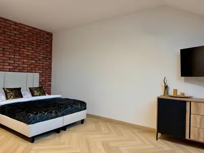 a bedroom with a bed and a flat screen tv at Willa Tulipanowa in Przeciszów