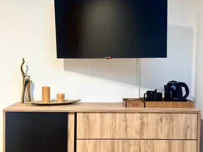 a flat screen tv on top of a wooden cabinet at Willa Tulipanowa in Przeciszów