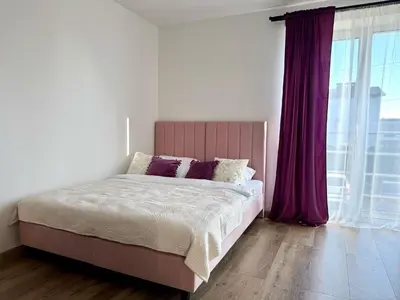 a bedroom with a large bed with purple curtains at Willa Tulipanowa in Przeciszów