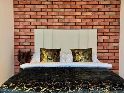 a bedroom with a brick wall and a bed at Willa Tulipanowa in Przeciszów