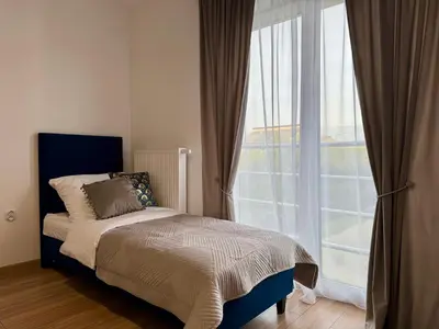 a bedroom with a bed and a large window at Willa Tulipanowa in Przeciszów