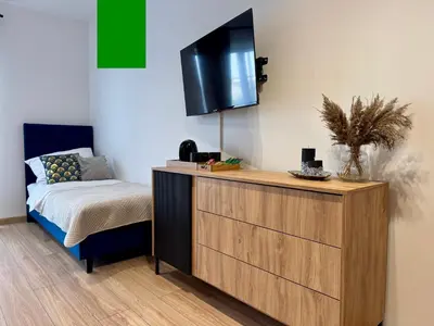 a bedroom with a dresser with a tv on the wall at Willa Tulipanowa in Przeciszów