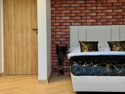 a bedroom with a brick wall and a bed at Willa Tulipanowa in Przeciszów