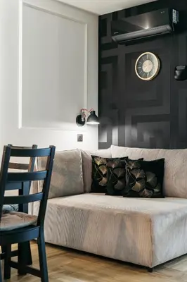 a couch in a living room with a clock on the wall at Native Apartments Kościuszki 39I27 in Kraków