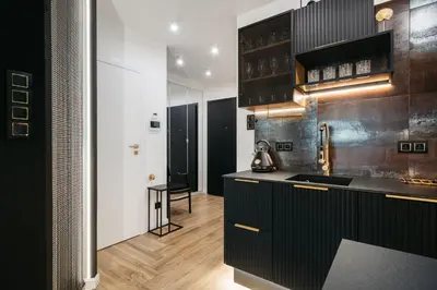 a kitchen with black cabinets and a black counter top at Native Apartments Kościuszki 39I27 in Kraków