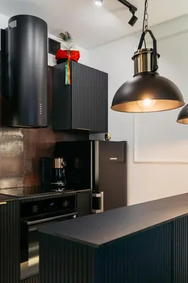a kitchen with a black counter top and a black appliance at Native Apartments Kościuszki 39I27 in Kraków