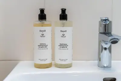 a group of three bottles sitting on top of a sink at Malila Premium Apartments Cracow Rynek Dębnicki 8 in Kraków