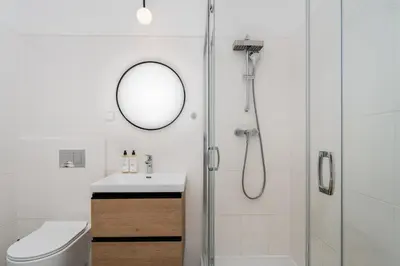 a bathroom with a shower and a sink and a mirror at Malila Premium Apartments Cracow Rynek Dębnicki 8 in Kraków