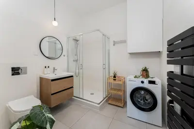 a bathroom with a shower and a washing machine at Malila Premium Apartments Cracow Rynek Dębnicki 8 in Kraków