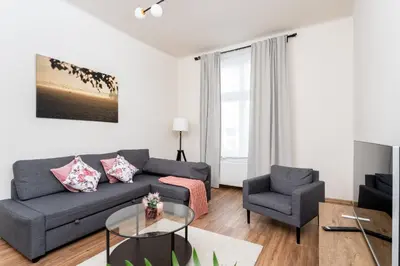 a living room with a couch and a chair at Malila Premium Apartments Cracow Rynek Dębnicki 8 in Kraków