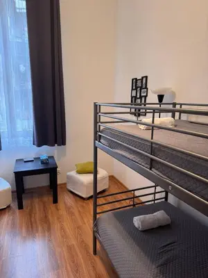 a room with two bunk beds and a table at Enios Rooms Hostel Zwierzyniecka 6 in Kraków