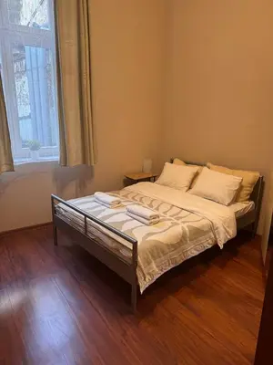 a large bed in a room with a window at Enios Rooms Hostel Zwierzyniecka 6 in Kraków