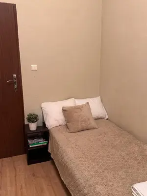 a small bedroom with a bed and a night stand at Enios Rooms Hostel Zwierzyniecka 6 in Kraków