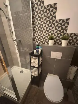 a small bathroom with a toilet and a shower at Enios Rooms Hostel Zwierzyniecka 6 in Kraków