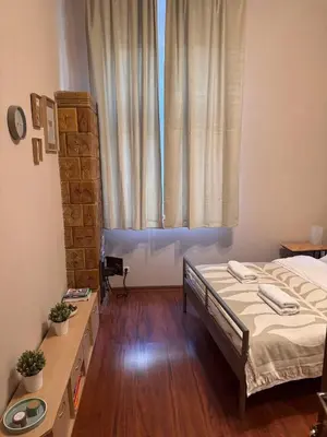 a bedroom with a bed and a large window at Enios Rooms Hostel Zwierzyniecka 6 in Kraków