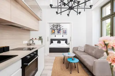 a kitchen and living room with a couch and tables at Modern Nest - in the Heart of Kraków - Old Town - by Upstairs in Kraków