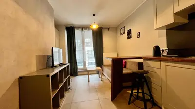 a small kitchen with a counter and a television at Small Studio in Kraków