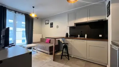 a kitchen with a table and a couch in a room at Small Studio in Kraków