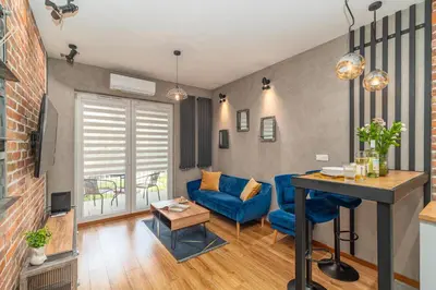 a living room with a blue couch and a table at Grzegórzki Apt - Top location and Parking by Rentujemy in Kraków