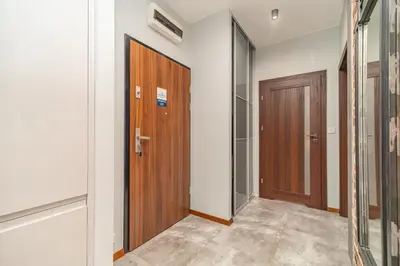 an empty hallway with a wooden door and a door at Grzegórzki Apt - Top location and Parking by Rentujemy in Kraków