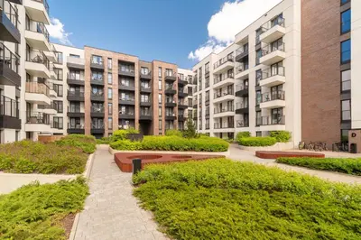 a row of apartment buildings with bushes in a courtyard at Grzegórzki Apt - Top location and Parking by Rentujemy in Kraków