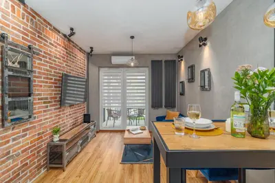 a room with a brick wall and a table with wine glasses at Grzegórzki Apt - Top location and Parking by Rentujemy in Kraków