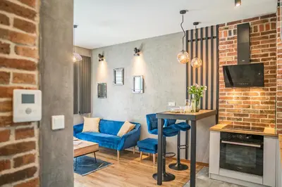 a living room with a blue couch and a table at Grzegórzki Apt - Top location and Parking by Rentujemy in Kraków