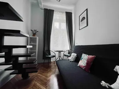 a living room with a bed and a table at Cosy apartment Heart of Krakow in Kraków