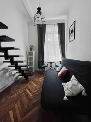 a bedroom with a black bed and a staircase at Cosy apartment Heart of Krakow in Kraków