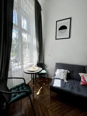 a living room with a couch and a table and a window at Cosy apartment Heart of Krakow in Kraków