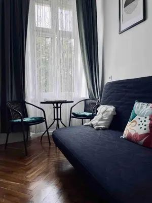 a living room with a couch and a table and a window at Cosy apartment Heart of Krakow in Kraków