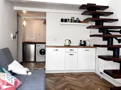 a kitchen with white cabinets and a spiral staircase at Cosy apartment Heart of Krakow in Kraków