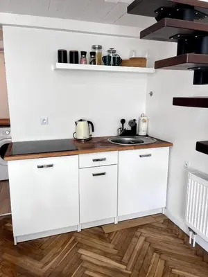 a kitchen with white cabinets and a sink at Cosy apartment Heart of Krakow in Kraków
