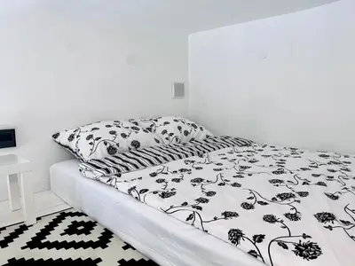 a bed with a black and white comforter on it at Cosy apartment Heart of Krakow in Kraków