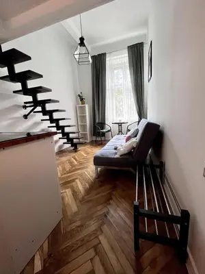 a living room with a couch and a spiral staircase at Cosy apartment Heart of Krakow in Kraków