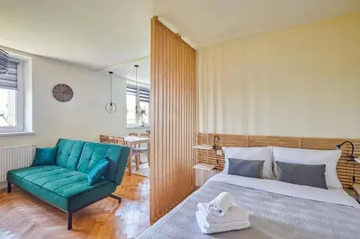 a bedroom with a bed and a green couch at Słowackiego Avenue Cozy Stay Studio by BookingHost in Kraków
