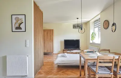 a living room with a table and a television at Słowackiego Avenue Cozy Stay Studio by BookingHost in Kraków
