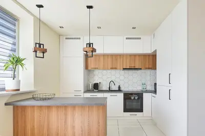 a kitchen with white cabinets and a counter top at Słowackiego Avenue Cozy Stay Studio by BookingHost in Kraków