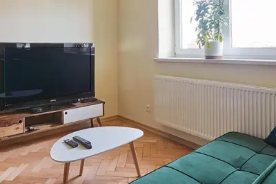 a living room with a couch and a tv at Słowackiego Avenue Cozy Stay Studio by BookingHost in Kraków