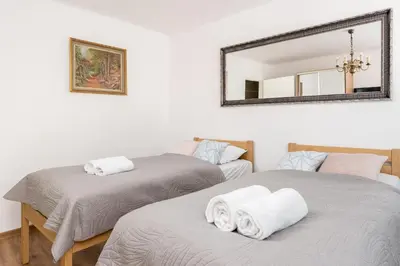 two twin beds in a room with a mirror at Grzegórzki Pleasant Apartment by BookingHost in Kraków