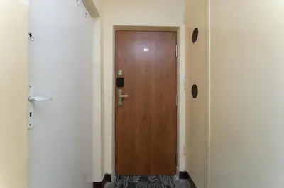 a hallway with a wooden door in a room at Grzegórzki Pleasant Apartment by BookingHost in Kraków
