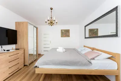 a bedroom with a bed and a flat screen tv at Grzegórzki Pleasant Apartment by BookingHost in Kraków