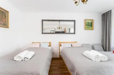 two beds in a room with a mirror on the wall at Grzegórzki Pleasant Apartment by BookingHost in Kraków