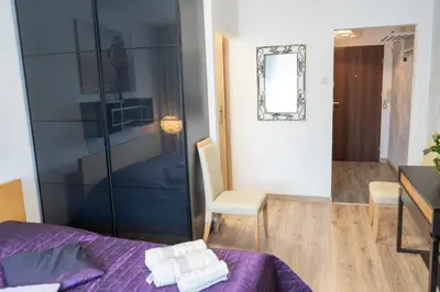 a bedroom with a purple bed and a mirror at Apartment Azory in Kraków