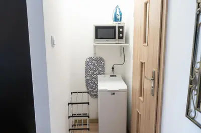 a bathroom with a small refrigerator and a microwave at Apartment Azory in Kraków
