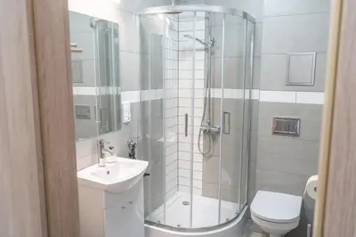 a bathroom with a shower and a sink and a toilet at Apartment Azory in Kraków