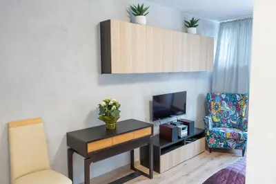 a living room with a table and a tv and a chair at Apartment Azory in Kraków