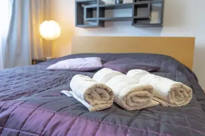 a pile of towels on top of a bed at Apartment Azory in Kraków